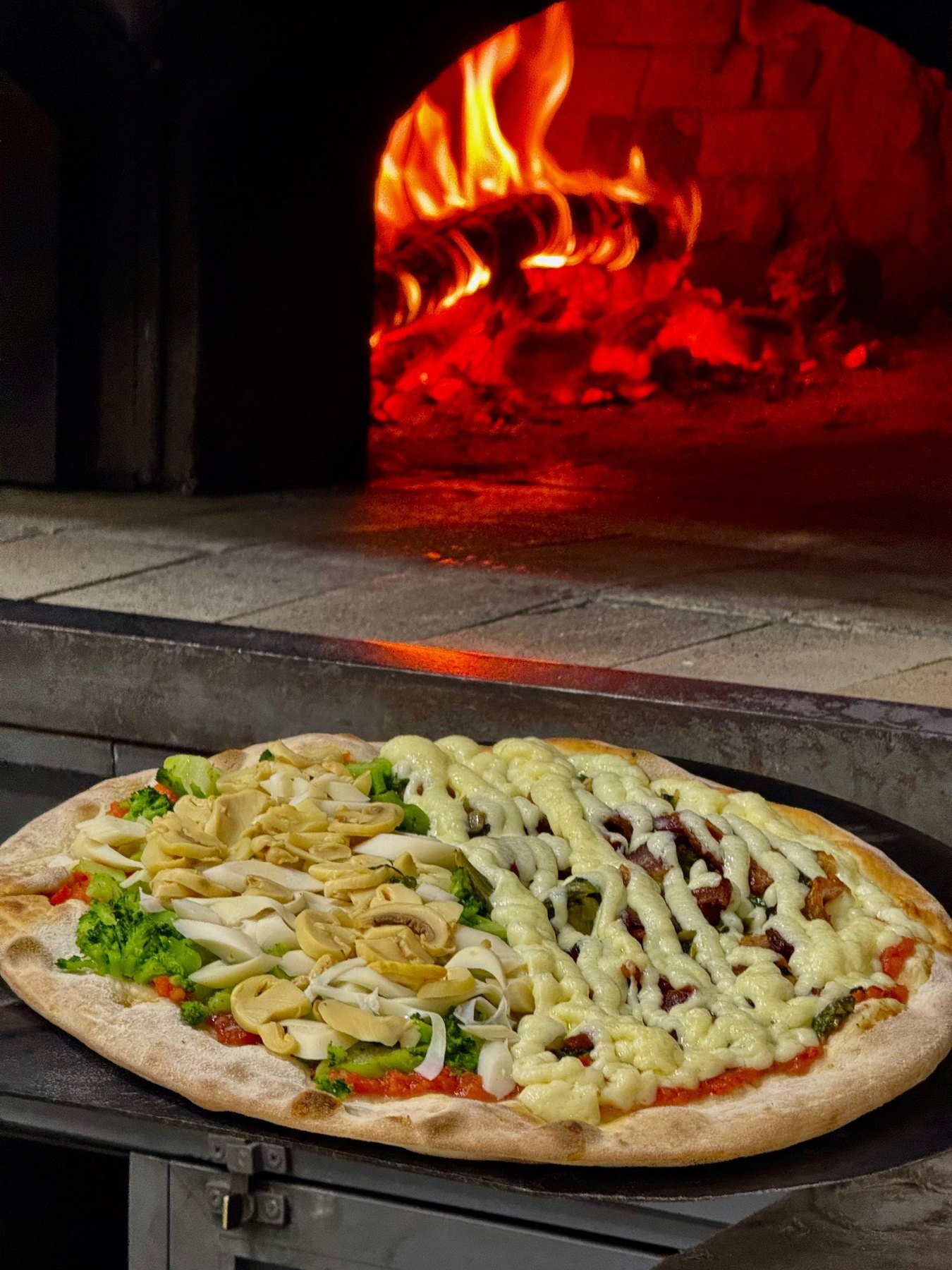 Pizza saindo do forno a lenha